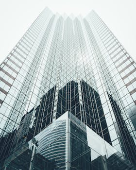 Striking low angle view of a modern skyscraper with reflective glass facade in a cityscape.